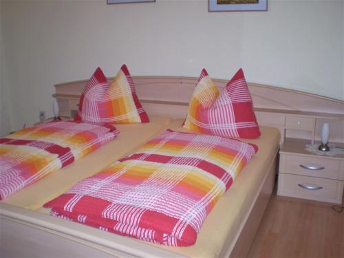 a bedroom with two beds with colorful pillows at Ferienwohnung Eckoldt in Eisenberg