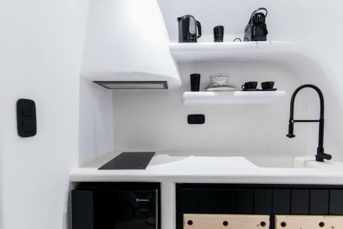 a white kitchen with a sink and a stove at Portara Seaside Luxury Suites in Naxos Chora