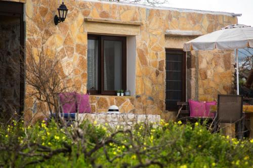 a building with a window with pink chairs and an umbrella at Μylos in Kissamos