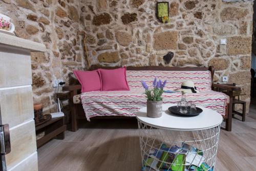 a room with a couch with pink pillows and a table at Μylos in Kissamos