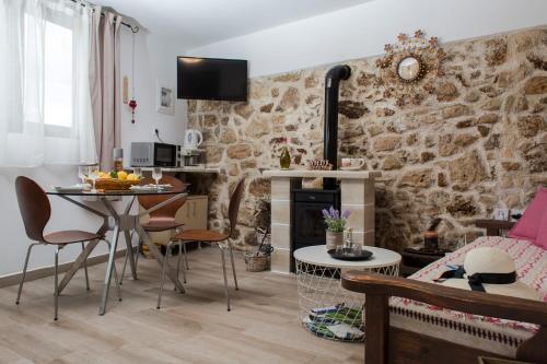 a living room with a table and a stone wall at Μylos in Kissamos