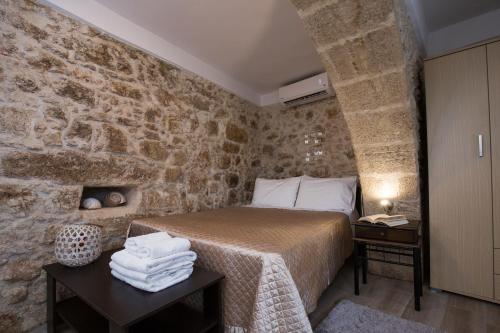 a bedroom with a bed and a stone wall at Μylos in Kissamos
