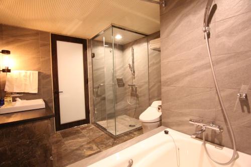 a bathroom with a shower and a toilet and a sink at Quintessa Hotel Sapporo in Sapporo