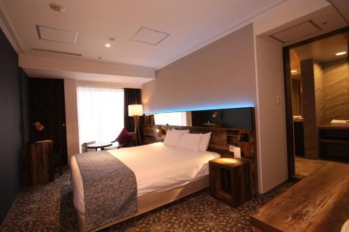 a hotel room with a bed and a mirror at Quintessa Hotel Sapporo in Sapporo