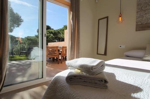 um quarto com 2 camas e uma porta de vidro deslizante em Petit Bijou - Beach apartment III em Castelldefels