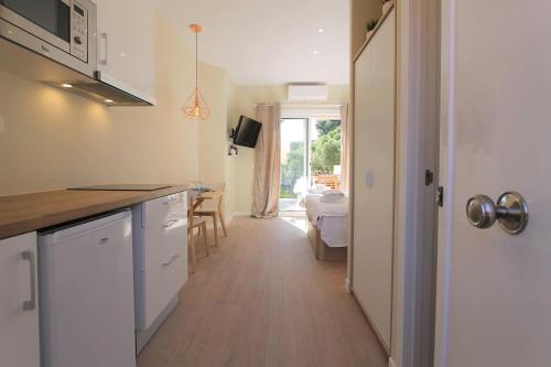 a kitchen with white cabinets and a dining room at Petit Bijou - Beach apartment III in Castelldefels