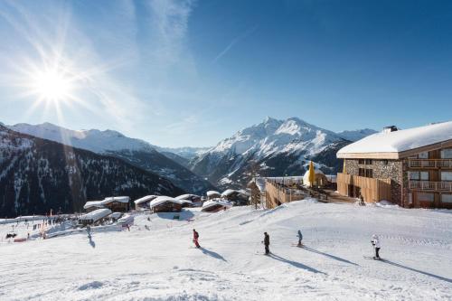a group of people skiing down a snow covered mountain at Hôtel Alparena & Spa - 4 étoiles in La Rosière
