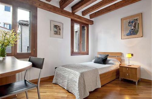 a bedroom with a bed and a desk at Salmaso Apartments in Venice