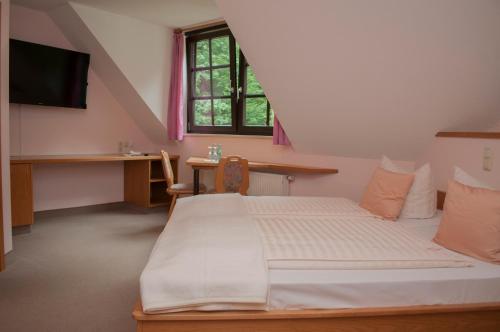 Schlafzimmer mit einem Bett, einem Schreibtisch und einem Fenster in der Unterkunft Waldfrieden Waldheim in Waldheim