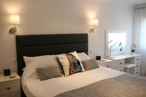 a bedroom with a large bed with a black headboard at Carvoeiro Bay Apartment in Carvoeiro