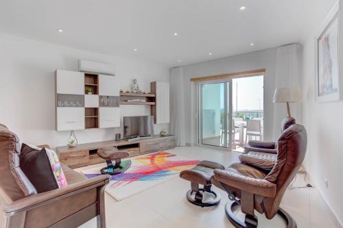 a living room with two chairs and a desk and a television at Carvoeiro Bay Apartment in Carvoeiro