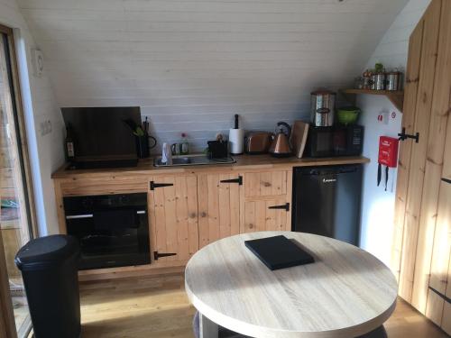 a kitchen with a wooden table and a counter top at Brynllwyd Glamping in Devils Bridge