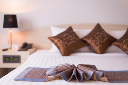 a bed with two folded towels on top of it at The Maruay Garden Hotel in Bangkok