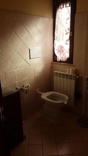 a bathroom with a toilet and a window at TENUTA MARTINO in Aquara