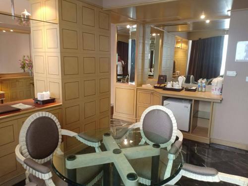 a room with a glass table and two chairs at The Maruay Garden Hotel in Bangkok