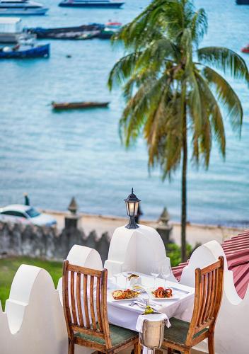 a table with food on it with a view of the ocean at The Seyyida Hotel and Spa in Zanzibar City