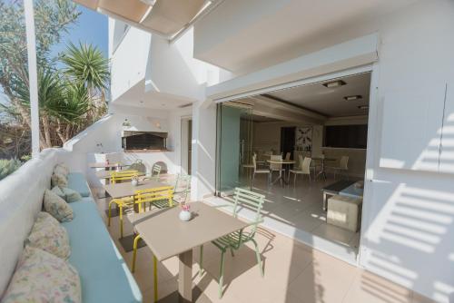una sala de estar de planta abierta con un sofá azul y mesas. en The Saint Vlassis, en Naxos Chora
