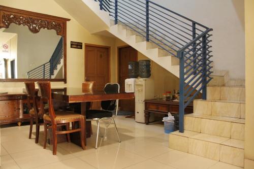 a living room with a table and a staircase at RedDoorz near Tomang 2 in Jakarta