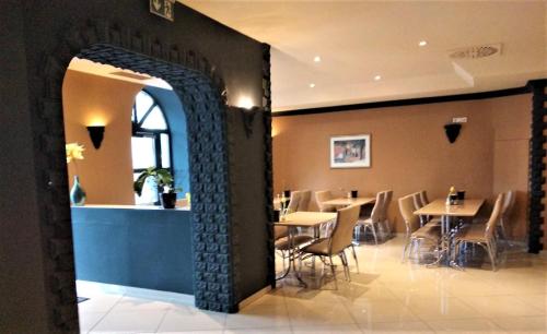 an archway in a restaurant with tables and chairs at M&A Cityhotel Hildesheim in Hildesheim