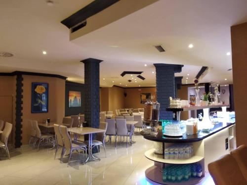 un restaurante con mesas y sillas y un bar en M&A Cityhotel Hildesheim, en Hildesheim