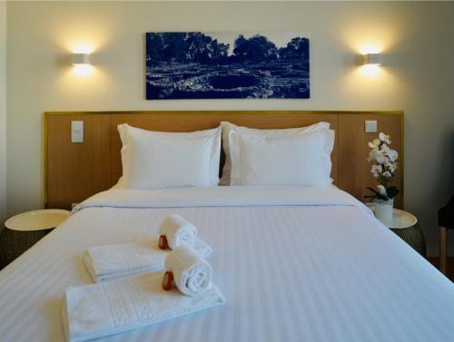 a hotel room with a bed with towels on it at ó Poboa Guesthouse in Póvoa de Varzim