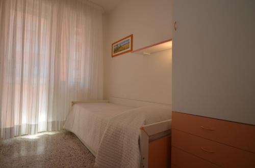 Habitación pequeña con cama y ventana en Appartamenti Dei Pini, en Bibione