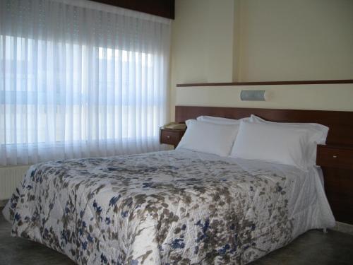 Schlafzimmer mit einem Bett und einem Fenster in der Unterkunft Hostal Roma in A Coruña