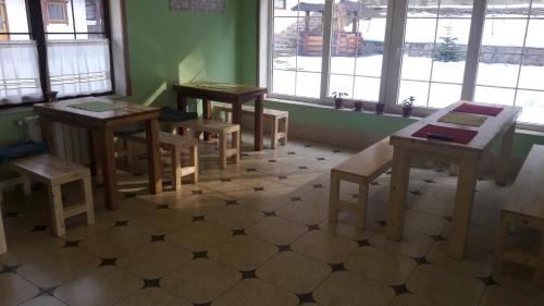 a room with tables and benches in a room with windows at U Druziv in Polyana