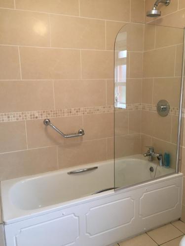 a bathroom with a bath tub with a shower at Shannon Oaks Apartments in Portumna