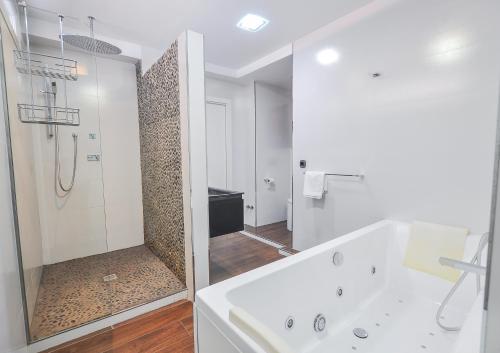 a white bathroom with a shower and a sink at Malagueta Beach in Málaga