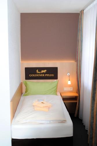 a hotel room with a bed with a sign on it at Landgasthof Goldener Pflug in Frasdorf