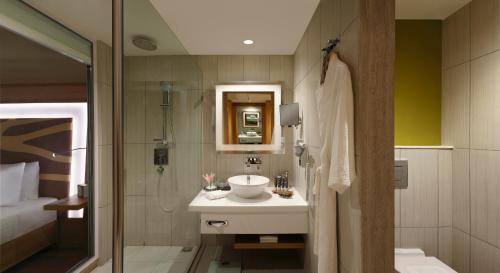 a bathroom with a sink and a shower at Novotel Chennai OMR in Chennai