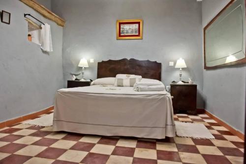 a bedroom with a bed and a checkered floor at LA POSADA in Medina de las Torres
