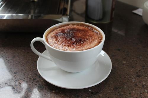 a cup of coffee on a white plate on a counter at The Summit Lodge in Gladstone