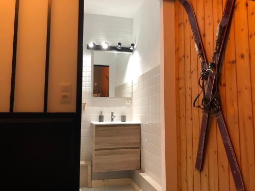 La salle de bains est pourvue d'une porte en bois et d'un lavabo. dans l'établissement LES AMBRUNES, à Châtel