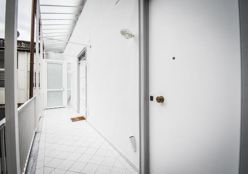 a hallway with a white floor and a glass door at Domus Sibyllina, Galleria Umberto I in Naples