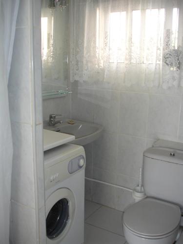 a bathroom with a toilet sink and a washing machine at Versalles - Zand Properties in Benidorm