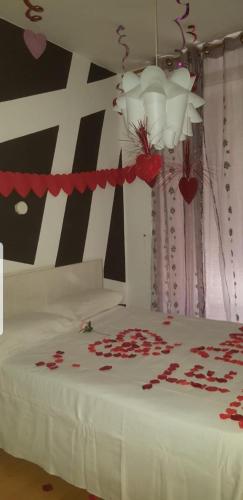 a bedroom with a bed with red roses on it at Hostal Lima in Valladolid