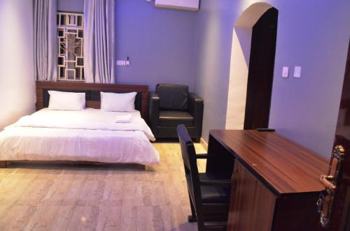 a bedroom with a bed and a desk and a chair at House X in Abuja