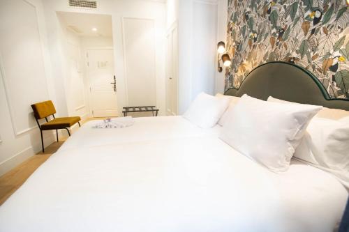 a bedroom with a large bed with white pillows at Soho Boutique Opera in Madrid