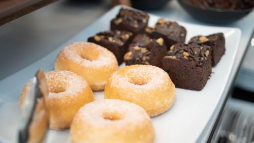 a white plate with donuts and other desserts on it at Soho Boutique Opera in Madrid