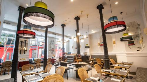 a restaurant with tables and chairs and lights at Soho Boutique Opera in Madrid