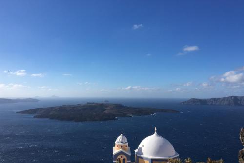 a church and an island in the water at Amelot Art Suites in Fira