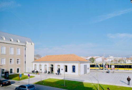 a building with a bus parked in a parking lot at ó Poboa Guesthouse in Póvoa de Varzim