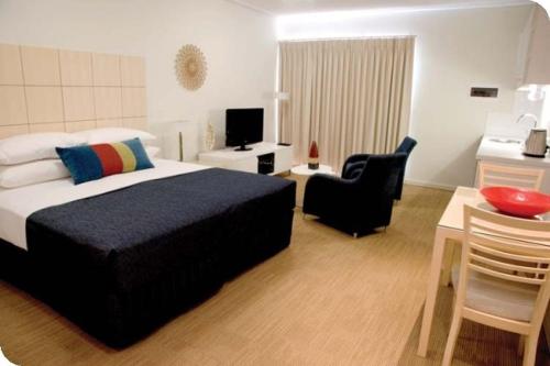 a bedroom with a bed and a desk and a chair at Broadwater Mariner Resort in Geraldton