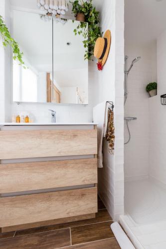 une salle de bain avec un lavabo et un miroir dans l'établissement Veeve - À la Mode Retreat by the Seine, à Paris