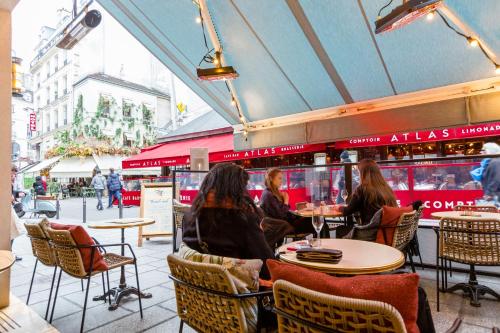 a group of people sitting at tables in a restaurant at Veeve - À la Mode Retreat by the Seine in Paris