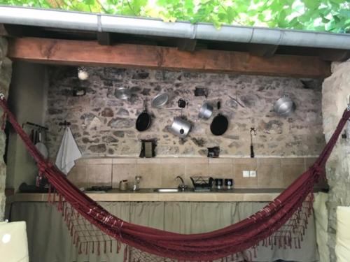 uma rede de descanso numa cozinha com uma parede de pedra em Stone House and Cottage Clio em Vrbanj
