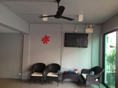 a room with four chairs and a flat screen tv at Chalong Sea Breeze in Chalong 