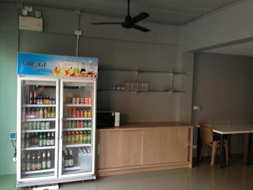 a refrigerator filled with drinks in a room at Chalong Sea Breeze in Chalong 